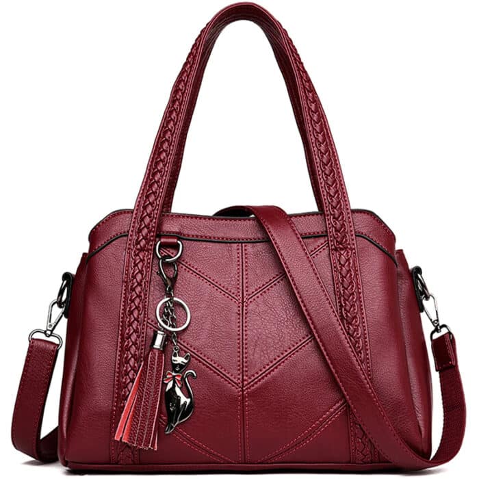 Grand sac à main rouge avec anses et bandoulière sur fond blanc.