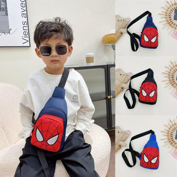 On voit un petit garçon qui porte un sac bleu Spider man. Il porte un sweat blanc, un pantalon noir et des lunettes de soleil larges.
