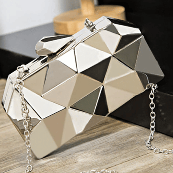 Photo d'un sac pochette à bandouière en 3D argent à demi posé sur une table en bois
