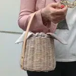 Anse de sac bandoulière en cuir végan marron clair sur sac en osier tressé