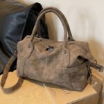 Sac bandoulière femme en cuir vegan kaki effet vintage, vue de trois quarts avec poches latérales