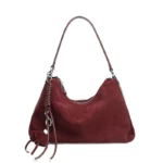 Sac hobo femme en cuir velours bordeaux avec breloque pompon, anse et fermeture zippée argentée